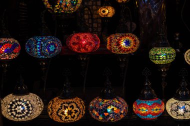 Yılbaşı dekoratif unsurları siyah arka planda şimşek şeklinde yıldız şeklinde güzel kağıt fenerler. Noel pazarında asılı parlak renkli festival yıldızları. Yeni yıl ve Noel konsepti.