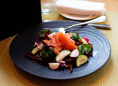 Ispanaklı somon salatası, vişneli domates, mısır salatası, ıspanak, taze nane ve fesleğen. Ev yapımı yemek. Lezzetli ve sağlıklı bir yemek konsepti. Karanlık taş arka plan. Üst Manzara. Kapat..