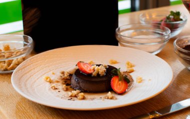 Dondurma ve beyaz tabakta çilekli çikolatalı kek.