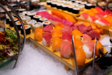 Maki, Nigiri 'li suşi tabağı, otel brunch büfesi sırasında havuz kenarındaki bahçede yuvarlanıyor..