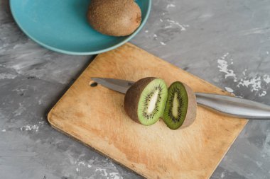 Bir kesme tahtası, beton arka plan üzerinde kivi