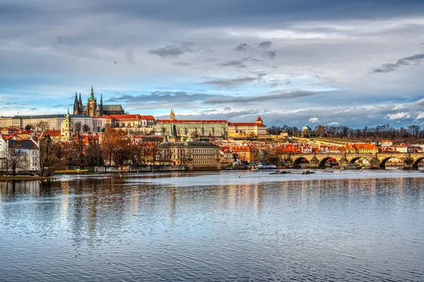 Historisk del av Prag med slott och katedral och charles bro vackert upplyst av solnedgången, tjeckisk präst — Stockfoto