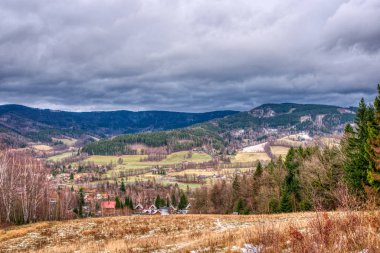 Yürüyüşçü kışın dağlarda yol boyunca yürür