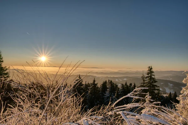 Luz dorada del sol sobre un idílico paisaje de invierno blanco con una pequeña cabaña de madera en el fondo — Foto de Stock