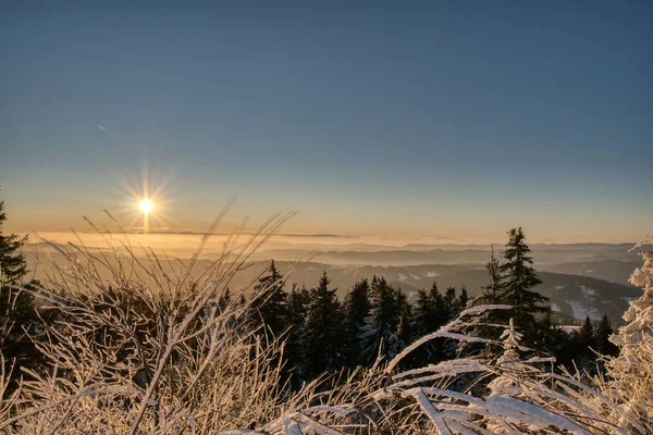 Luz dorada del sol sobre un idílico paisaje de invierno blanco con una pequeña cabaña de madera en el fondo — Foto de Stock