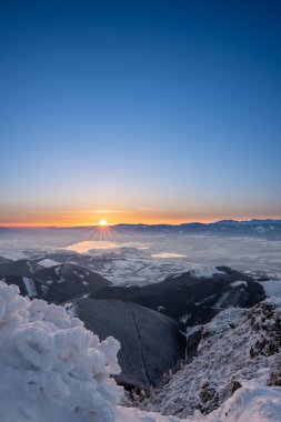 Kış mevsiminde Velky Choc dağından kış doğarken vadide sis, alçak ve yüksek Tatras ve Liptovska Mara manzarası, Slovakya
