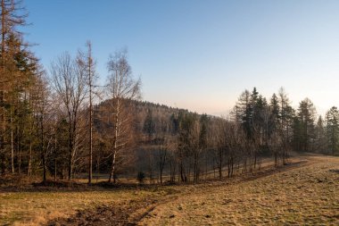 İlkbaharda toprak yolda, sabah güneş doğarken dağlarda.
