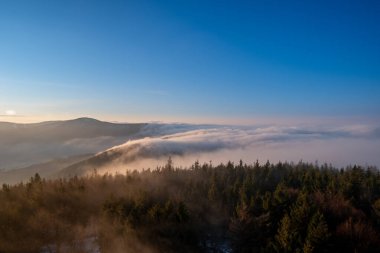 Dağlarda gün doğumunda güzel aydınlatılmış sis, Çek Beskydy