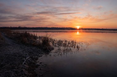 Gölün üzerinde güneşin gölün ve baharın üzerindeki yansımasıyla muhteşem bir gün doğumu.