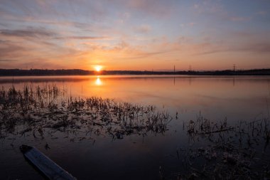 Gölün üzerinde güneşin gölün ve baharın üzerindeki yansımasıyla muhteşem bir gün doğumu.