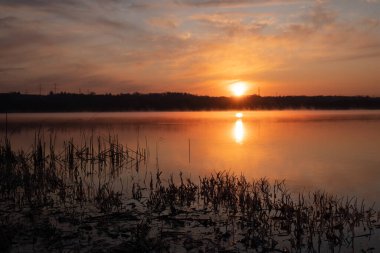 Gölün üzerinde güneşin gölün ve baharın üzerindeki yansımasıyla muhteşem bir gün doğumu.