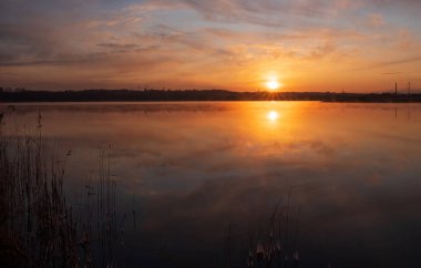 Gölün üzerinde güneşin gölün ve baharın üzerindeki yansımasıyla muhteşem bir gün doğumu.
