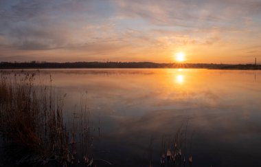 Gölün üzerinde güneşin gölün ve baharın üzerindeki yansımasıyla muhteşem bir gün doğumu.