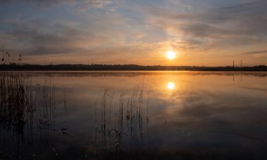 Gölün üzerinde güneşin gölün ve baharın üzerindeki yansımasıyla muhteşem bir gün doğumu.