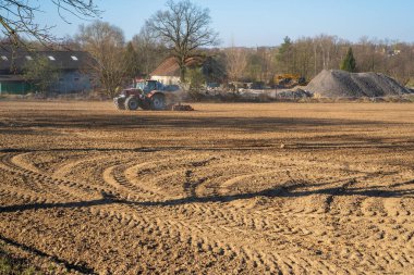 Traktör hasat tarlasında çalışıyor.