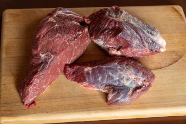 Tahta kesme tahtasındaki çiğ et parçası.