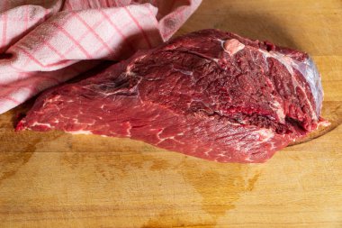 Tahta kesme tahtasındaki çiğ et parçası.