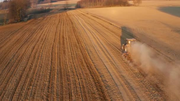Luftaufnahme des Traktors beim Ackerbau auf dem Hof am Morgen des Sonnenaufgangs — Stockvideo