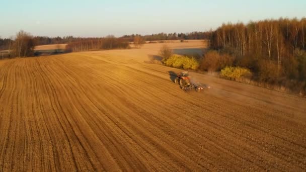 Widok z lotu ptaka Ciągnika uprawiającego ziemię na farmie o wschodzie słońca — Wideo stockowe