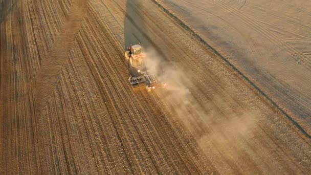 Vue aérienne du champ de labour du tracteur au lever du soleil. Tourné sur un drone — Video