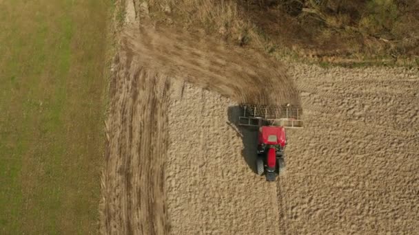 現場で頑丈な秋の耕作を行う農業トラクターの空中ビュー、ドローンのpovからのトップビュー — ストック動画
