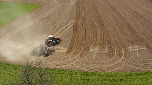 Traktor dra mark odlingsmaskin för sådd förberedelse före regn. Molnig vårdag. 4K flygfotfäste — Stockvideo