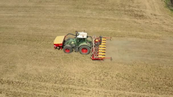 Jordbruksman på traktor med såmaskin för sådd av grödor på åkern och damm stiger upp — Stockvideo