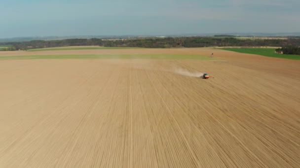 Bovenaanzicht van zeugen voor landbouwmachines. Tractor zaait maïs. Voorjaar zaaien. Moderne trekker zaait het veld met tarwezaden. Boer met een tractor zaait maïs op zijn veld. — Stockvideo