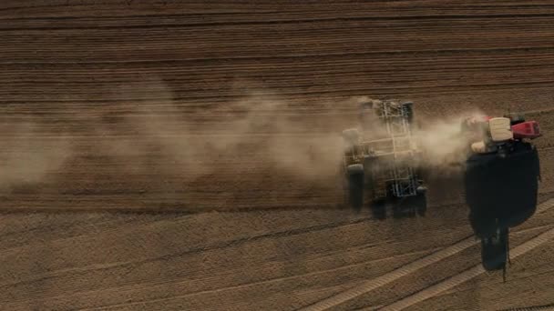 Top down antenn vy över grön traktor odla marken och sådd ett torrt fält. Jordbrukare som förbereder mark med såbäddskultivator som en del av försåddsaktiviteter tidigt på våren. — Stockvideo