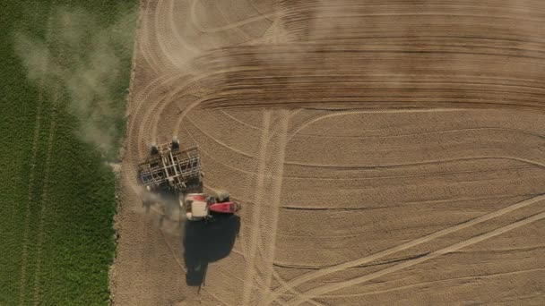 Stonava, Czech - 08. dubna 2020: Traktor obdělává půdu a osévá suché pole. Farmář připravuje půdu se semenným kultivátorem v rámci předsevu na začátku jarního období. — Stock video