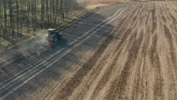 Ciągnik uprawia grunt i sieje suche pole. Rolnik przygotowujący grunty z uprawą sadzonek w ramach wstępnego siewu wczesną wiosną. — Wideo stockowe