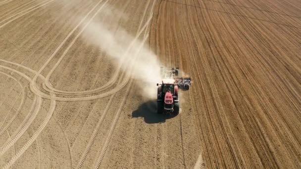 Большой трактор бороновал вспаханное поле — стоковое видео