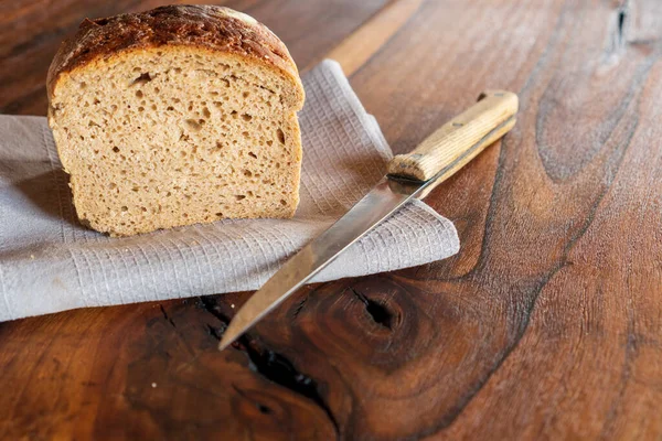 Fresh round crisp bread with caraway on wooden table.