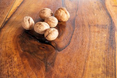 Ceviz çekirdekleri ve eski ahşap masadaki cevizler.