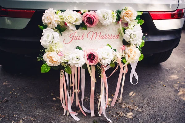 A placa de casamento "JUST MARRIED" para o carro é decorada com — Fotografia de Stock