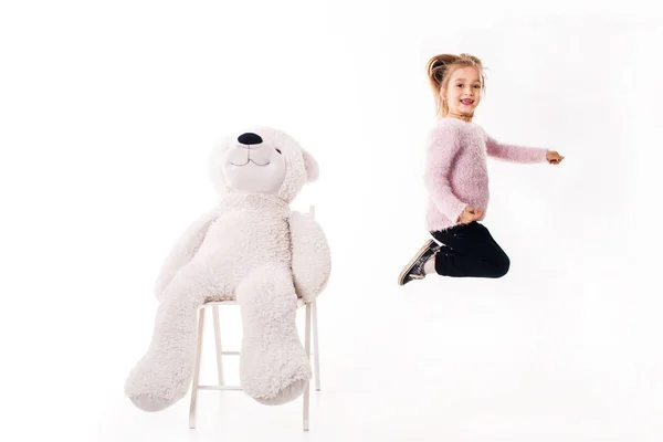 Meisje en een grote witte teddy beer. — Stockfoto