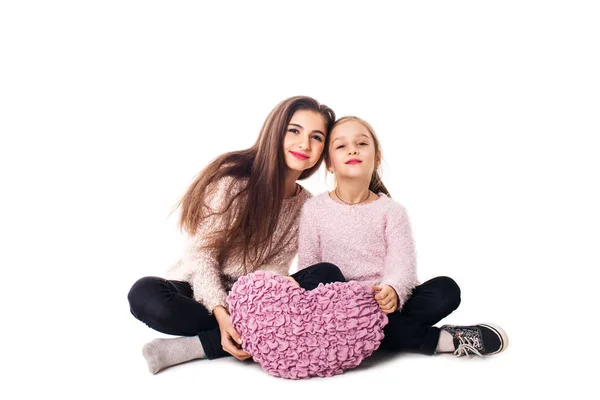 เด็กผู้หญิงสองคนนั่งและถือหมอนไว้ในมือ — ภาพถ่ายสต็อก