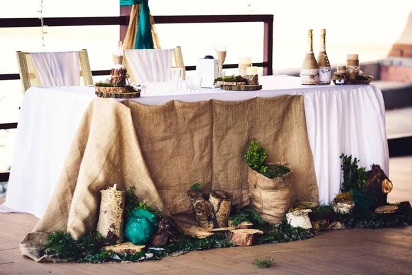 Украшение свадебного стола в деревенском стиле с мешковиной, пнями, свечами, зеленью . — стоковое фото