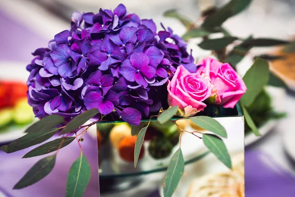 A decoração da mesa de casamento: velas e um buquê floral . — Fotografia de Stock