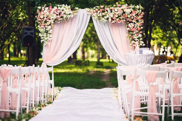 Cerimônia de casamento decoração no verão no parque: um arco, cadeiras, flores, caminho . — Fotografia de Stock