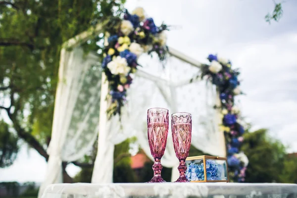 Arco de casamento bonito e mesa com óculos na natureza. Decorações de casamento . — Fotografia de Stock