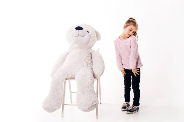 Meisje en een grote witte teddy beer. Geïsoleerd op witte achtergrond. — Stockfoto