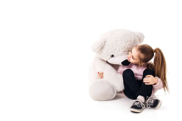 Meisje en een grote witte teddy beer. Geïsoleerd op witte achtergrond. — Stockfoto