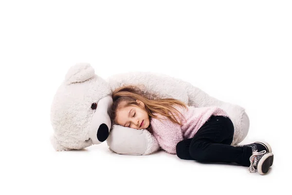 Niña y un osito de peluche blanco. Aislado sobre fondo blanco . — Foto de Stock