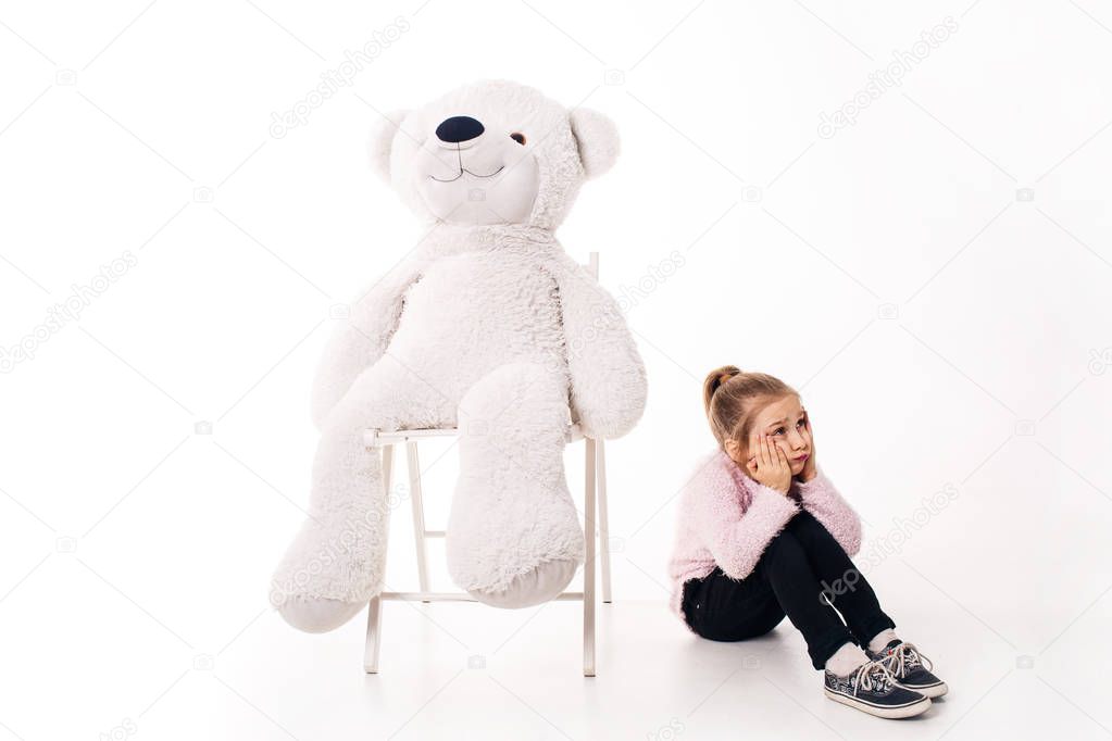 Little girl and a big white teddy bear. Isolated on white background.