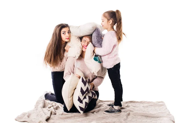 Máma a dvě dcery s polštáři sedět a radostně přijmout. — Stock fotografie