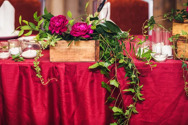 A mesa de casamento está decorada com peônias, galhos de hera e velas. Estilo rústico — Fotografia de Stock