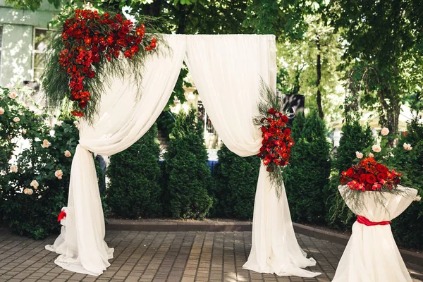 Arco de casamento e mesa decorada com flores . — Fotografia de Stock