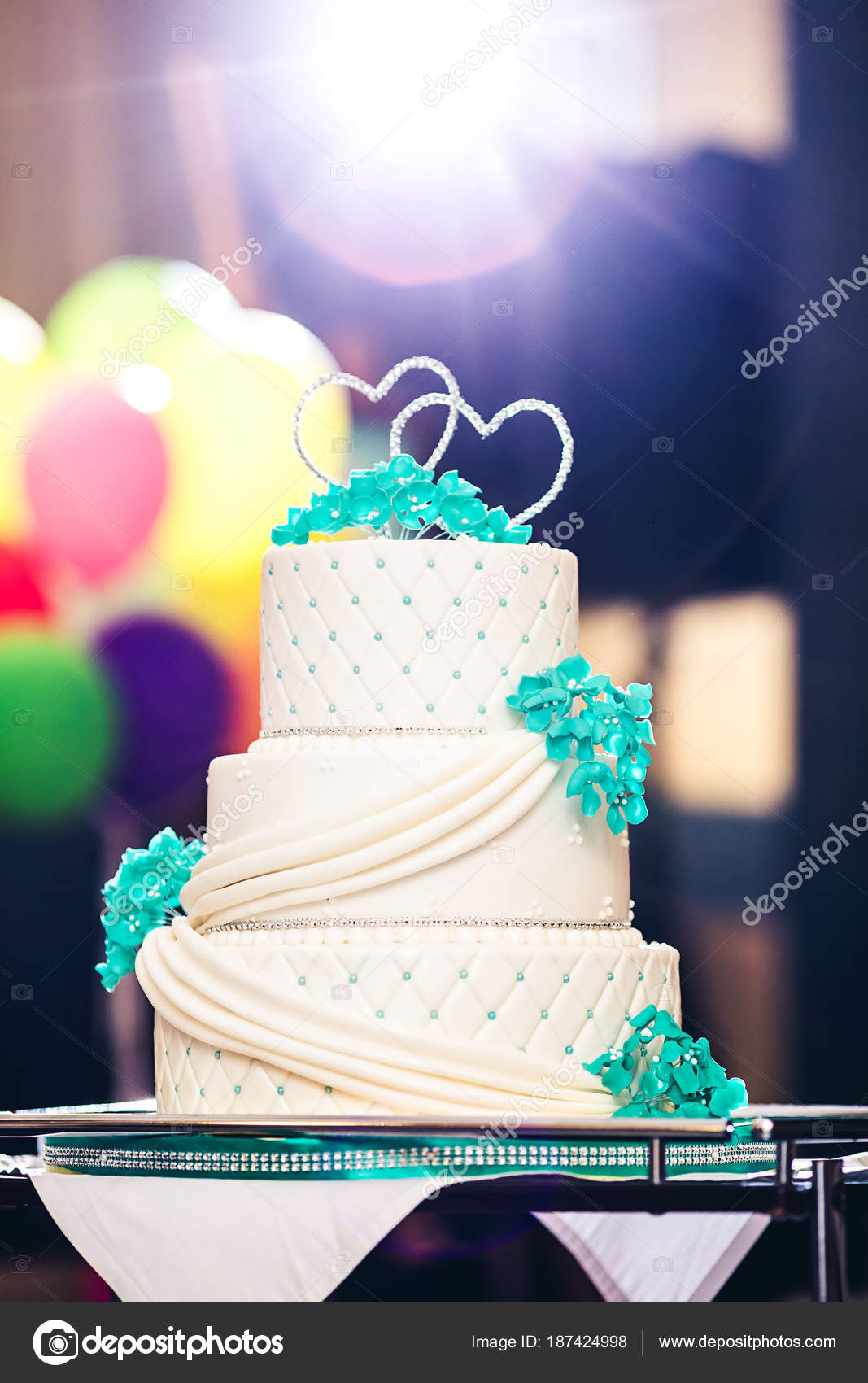 Una bella torta nuziale decorata con fiori blu, strass e cuori. Retroilluminazione \u2014 Foto