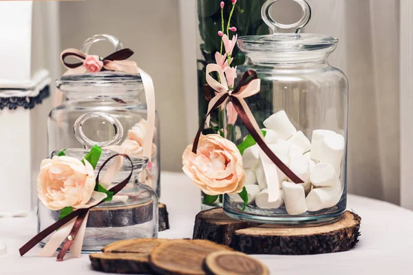 Decoração em mesa festiva: marshmallow em jarro, círculos seção transversal de árvore, flores . — Fotografia de Stock